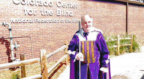 Tom Anderson in a latter-day purple velvet suit beside CCB's sign