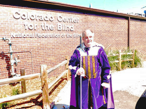 Tom Anderson in a latter-day purple velvet suit beside CCB's sign