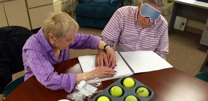A senior woman and man explore a Braille cell with touch