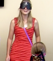 A smiling young woman wearing sleepshades