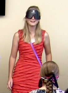 A smiling young woman wearing sleepshades