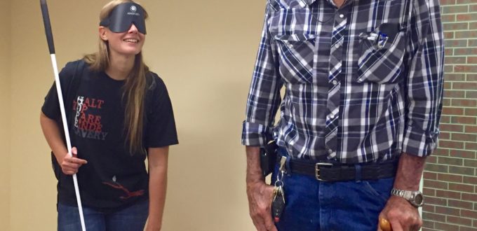 Woman in sleepshades shows visitor a Tech Lab