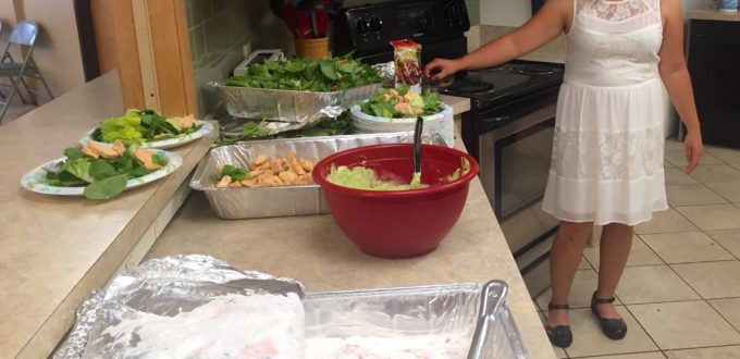 Looking down the serving area over all the trays of food as Cindy stands telling us about what she prepared