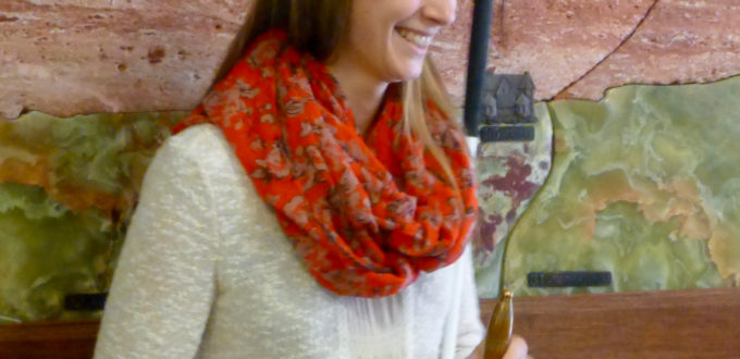 Tabea grins as she holds her bell of freedom
