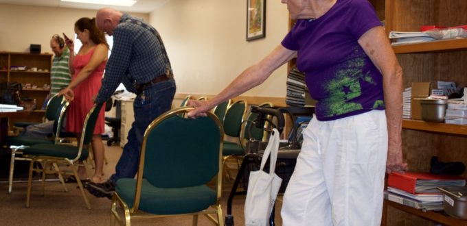 A young woman in line with three seniors exercising