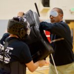 Warren holds on to his cane while throwing elbow jabbs at the pads