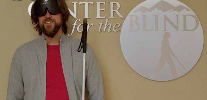 Graham standing in front of the CCB logo in the front lobby