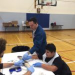 Professor Leans in to point something out on the shark to CCB student Ethan working with middle-schooler Jaden