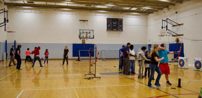 A group of Martial Arts Students to the left and a row of Archery Students to the right