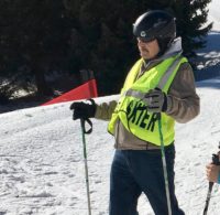 John on the slope with ski poles and snowshoes