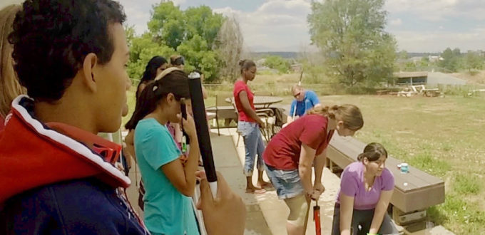 Jamie (bottom right) holding the rocket with a group of CCB youth launching water rockets