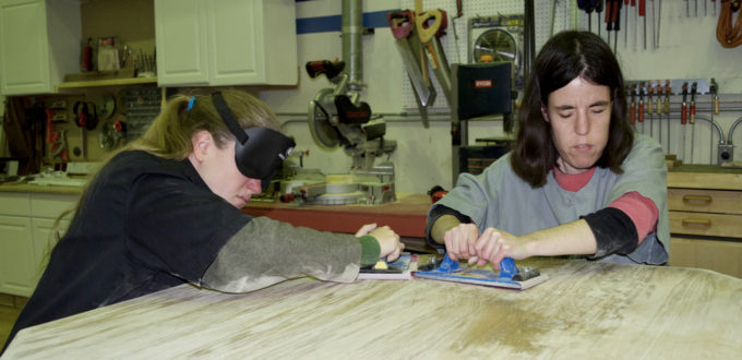 Serena sand an oak table in woodshop