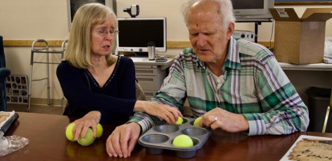 Steve works with Janet to learn the Braille Alphabet using a muffin tin and tennis balls