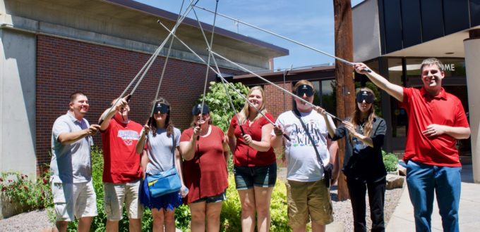 Summer staff with canes crossed in the air
