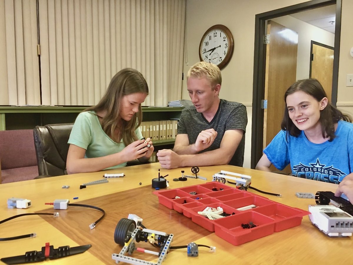 Trevor with Maggie and Amy assembling robots