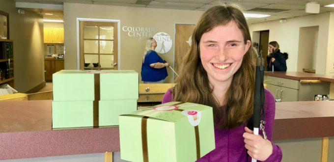 Rebecca beams a smile as she holds up a box of her Birthday cupcakes