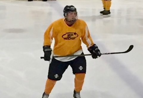 Daniel in full Hockey gear in action on the ice