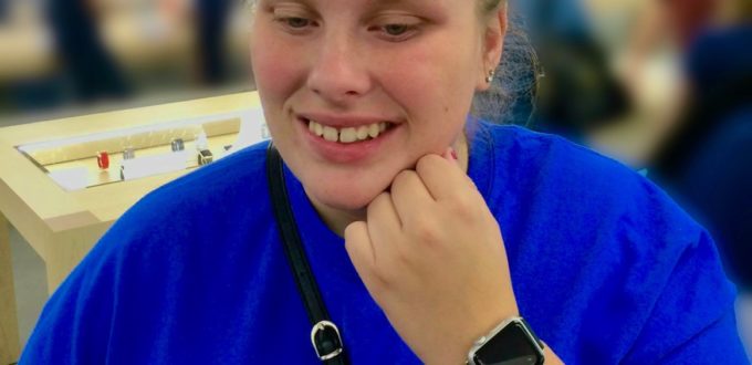 Grinning, Megan shows the Apple watch on her wrist to the camera