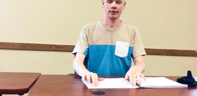 Luther Fuller of Kansas reading Braille before the National Braille Challenge