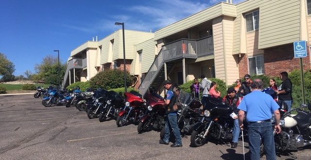 CCB students and staff gather near a row of motorcycles lined up in front of the McGeorge Mountain Terrace Apartments