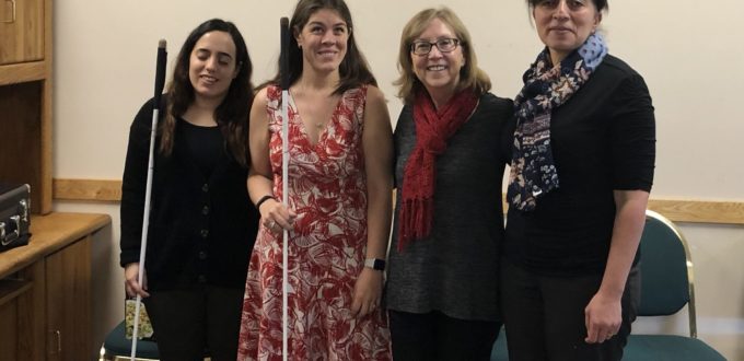 Four smiling women stand together in the Senior Resource Room