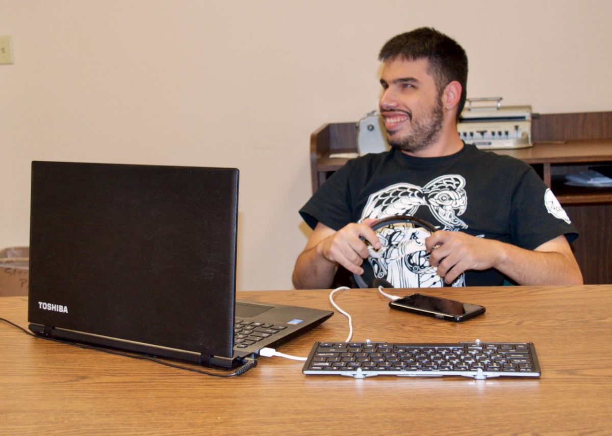 CCB Summer Tech Instructor engaged with his laptop and Smart Phone